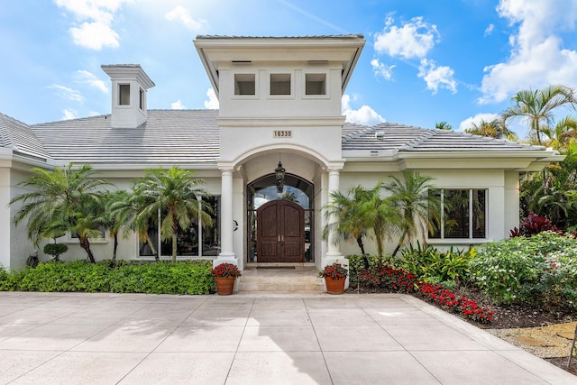 16330 Vintage Oaks Ln, Delray Beach, FL 33484 - view of exterior entry with a tile roof and stucco siding