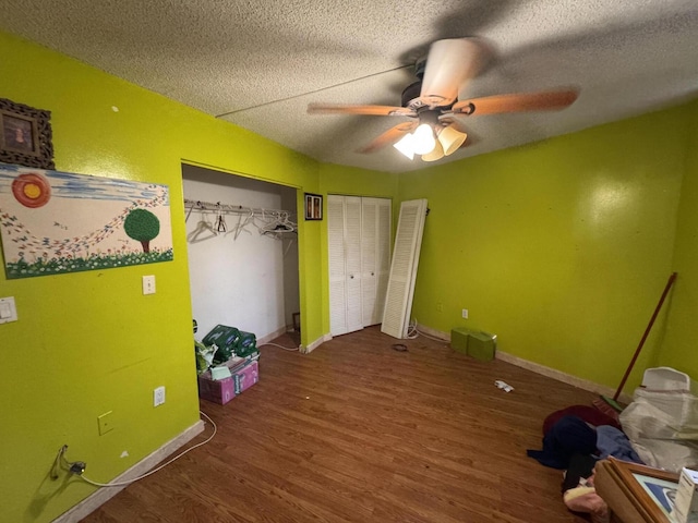 1400 Saint Charles Pl Unit 317, Pembroke Pines, FL 33026 - unfurnished bedroom with wood finished floors, a textured ceiling, baseboards, a ceiling fan, and two closets