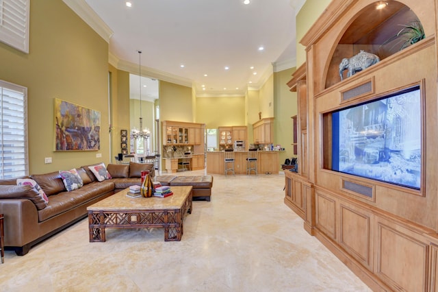 living area featuring an inviting chandelier, ornamental molding, recessed lighting, and a high ceiling