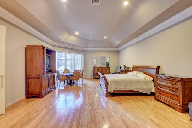 bedroom with light wood-type flooring, recessed lighting, and a tray ceiling
