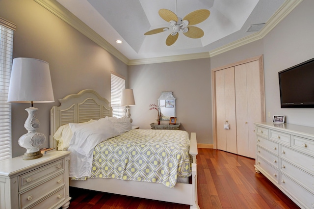 bedroom with ceiling fan, dark wood-style flooring, crown molding, a tray ceiling, and recessed lighting