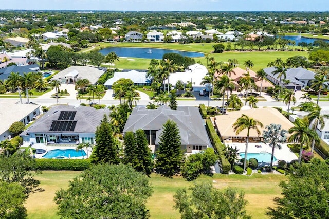 drone / aerial view with a residential view, a water view, and golf course view