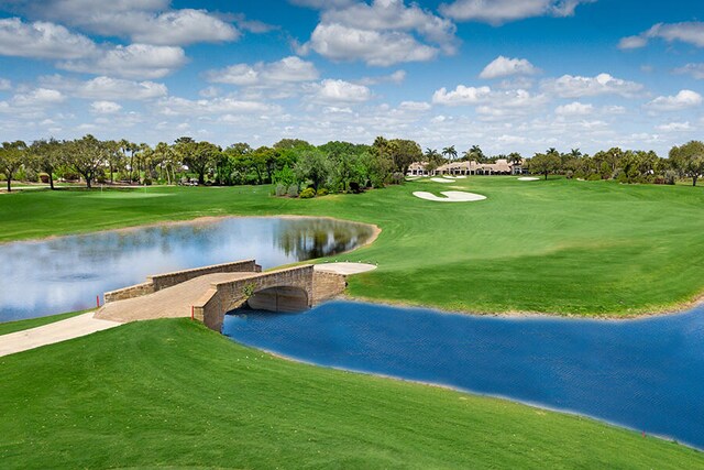 surrounding community featuring a water view, a yard, and golf course view