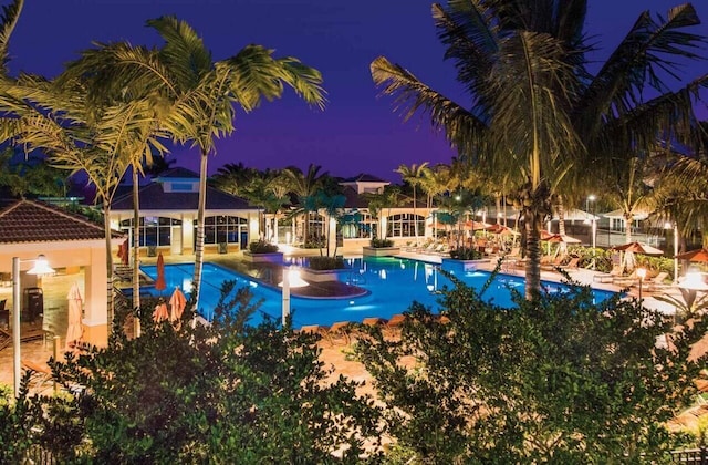 pool at twilight with a community pool and a patio