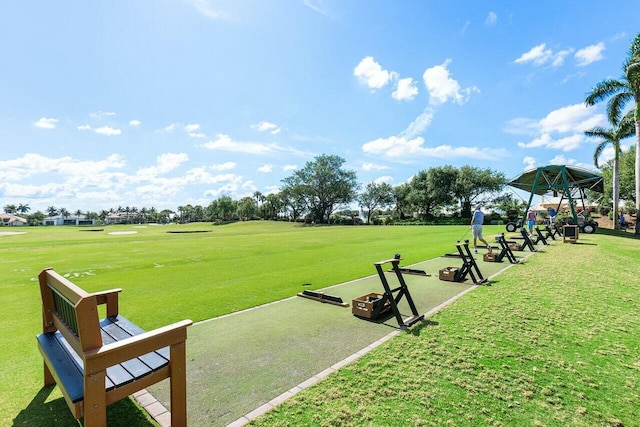view of community with a yard and view of golf course