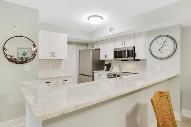 254 Village Blvd Unit 4207, Tequesta, FL 33469 - kitchen with stainless steel appliances, baseboards, and light stone countertops