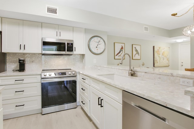 254 Village Blvd Unit 4207, Tequesta, FL 33469 - kitchen featuring stainless steel appliances, a sink, light stone countertops, and white cabinetry