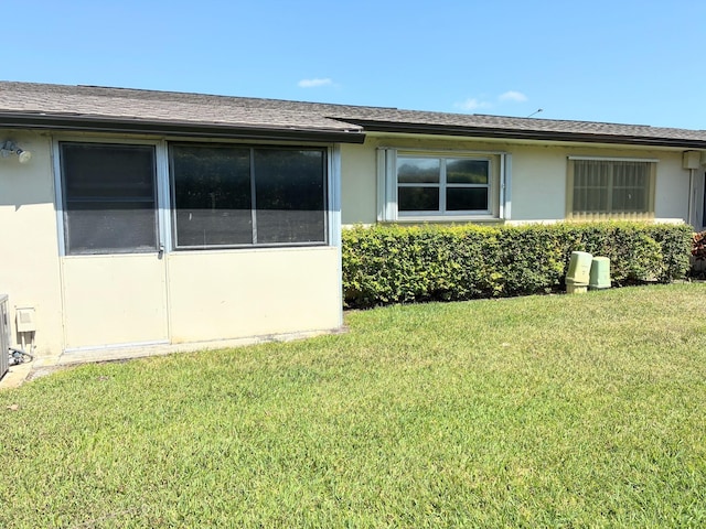 view of side of home featuring a yard and stucco siding