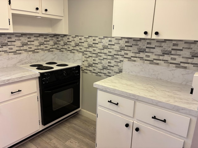 kitchen featuring light countertops, backsplash, and black range with electric stovetop