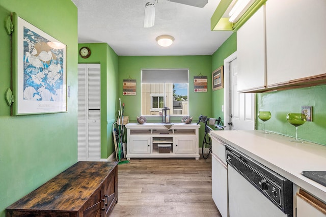 kitchen featuring light countertops, white cabinets, light wood-type flooring, and dishwasher