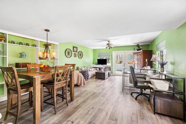 dining area featuring french doors, ceiling fan with notable chandelier, and wood finished floors