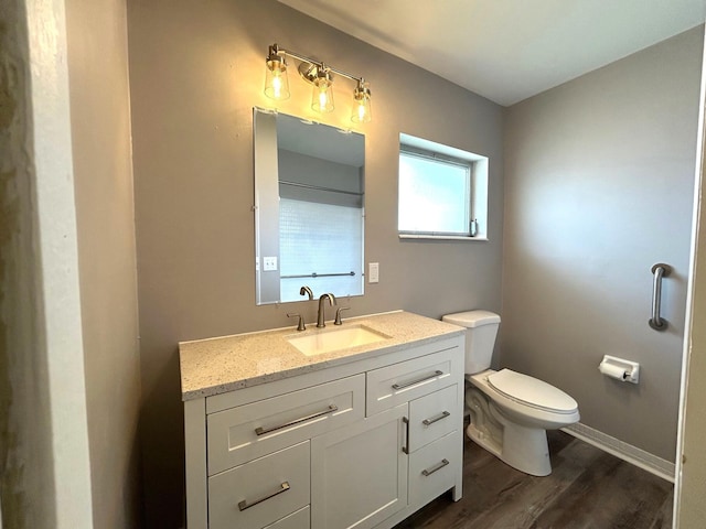 bathroom with vanity, wood finished floors, and toilet