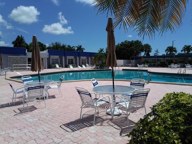 community pool featuring a patio and fence