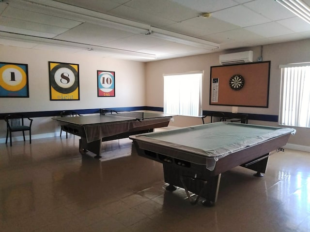 recreation room with pool table, a wall mounted AC, baseboards, tile patterned floors, and a drop ceiling