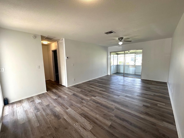 spare room with visible vents, dark wood-style flooring, baseboards, a textured ceiling, and a ceiling fan