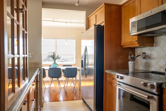 2500 E Las Olas Blvd Unit 802, Fort Lauderdale, FL 33301 - kitchen featuring appliances with stainless steel finishes, backsplash, and brown cabinets