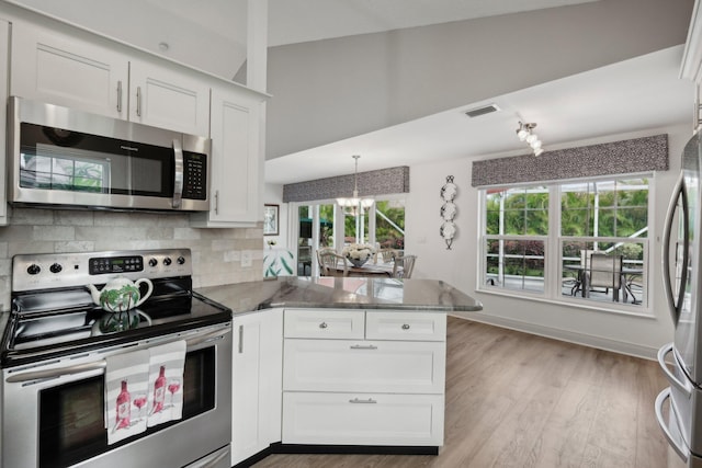 kitchen featuring white cabinets, a notable chandelier, appliances with stainless steel finishes, a peninsula, and wood finished floors