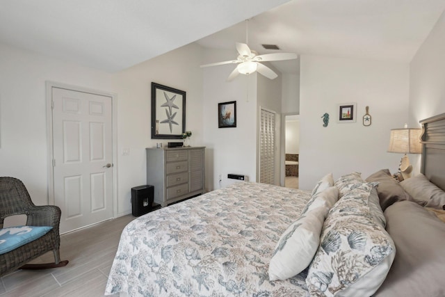 bedroom featuring light wood-type flooring, a ceiling fan, lofted ceiling, and visible vents