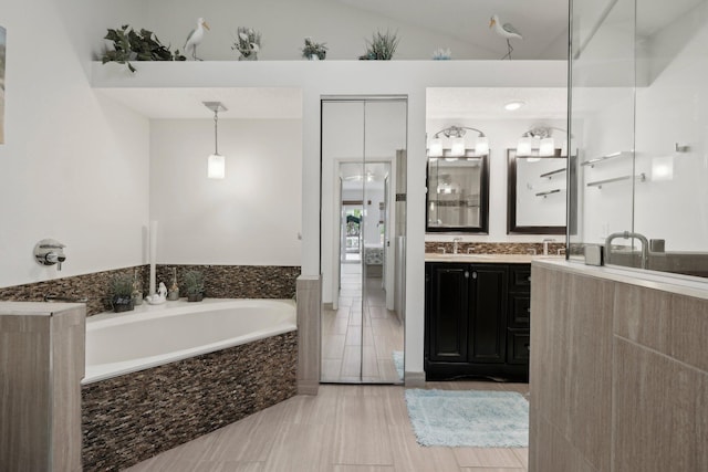 bathroom featuring double vanity, a sink, and a bath