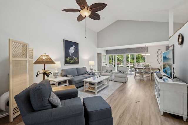 living room with high vaulted ceiling, ceiling fan with notable chandelier, and light wood-type flooring