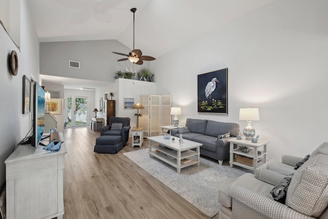 living room featuring visible vents, a ceiling fan, light wood-style flooring, and high vaulted ceiling