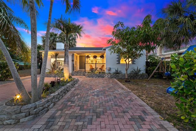 425 32nd St, West Palm Beach, FL 33407 - view of front of house with stucco siding, fence, and a porch