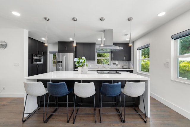 425 32nd St, West Palm Beach, FL 33407 - kitchen featuring high quality fridge, island exhaust hood, dark cabinetry, a sink, and a large island