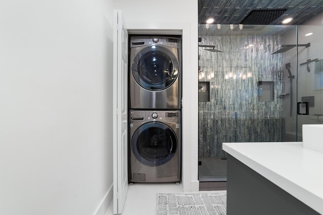 425 32nd St, West Palm Beach, FL 33407 - laundry area featuring stacked washer and clothes dryer and baseboards
