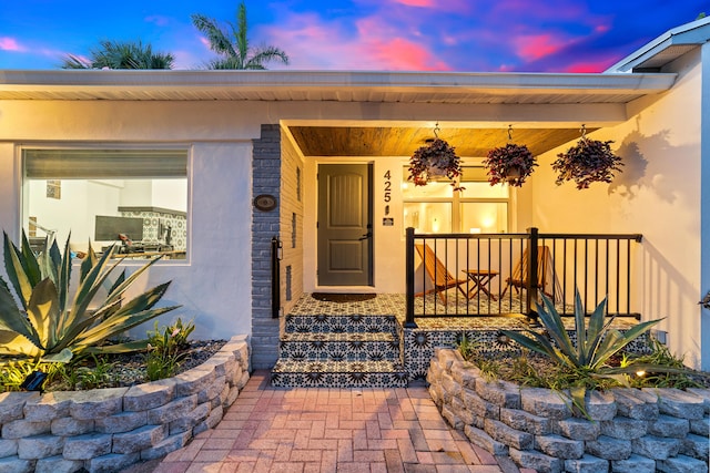 425 32nd St, West Palm Beach, FL 33407 - exterior entry at dusk with stucco siding and covered porch