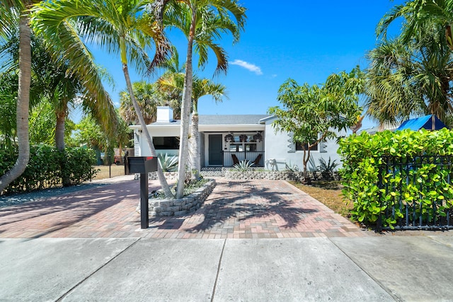 425 32nd St, West Palm Beach, FL 33407 - view of front facade featuring stucco siding, fence, and decorative driveway