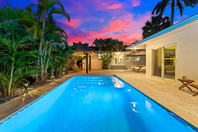 425 32nd St, West Palm Beach, FL 33407 - pool at dusk featuring a patio, an outdoor pool, and outdoor dining space