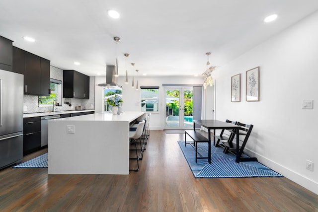 425 32nd St, West Palm Beach, FL 33407 - kitchen featuring stainless steel appliances, light countertops, island exhaust hood, a center island, and a breakfast bar area