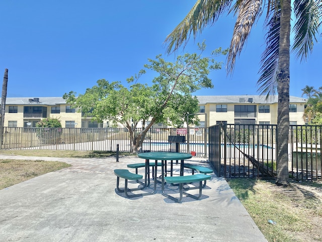 surrounding community with fence and a swimming pool