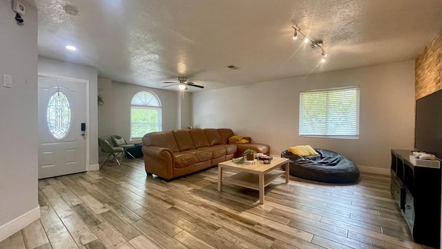 1044 Nin St, Orlando, FL 32835 - living area featuring a textured ceiling, light wood-style floors, baseboards, and a ceiling fan