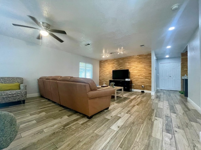 1044 Nin St, Orlando, FL 32835 - living room featuring light wood-style floors, rail lighting, a textured ceiling, baseboards, and ceiling fan