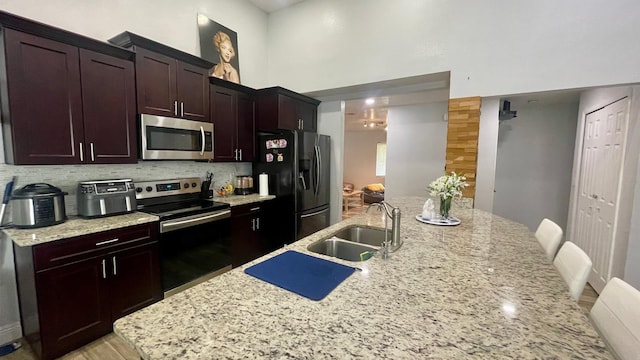 1044 Nin St, Orlando, FL 32835 - kitchen with appliances with stainless steel finishes, a sink, a high ceiling, backsplash, and a spacious island