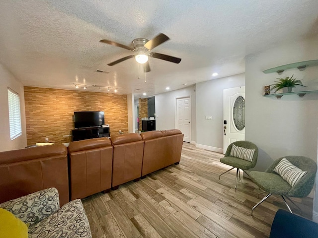 1044 Nin St, Orlando, FL 32835 - living area with light wood-style flooring, a ceiling fan, a textured ceiling, rail lighting, and baseboards