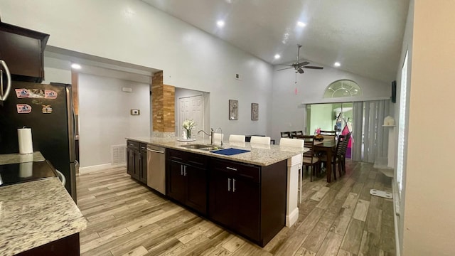 1044 Nin St, Orlando, FL 32835 - kitchen featuring appliances with stainless steel finishes, ceiling fan, high vaulted ceiling, light wood finished floors, and a sink