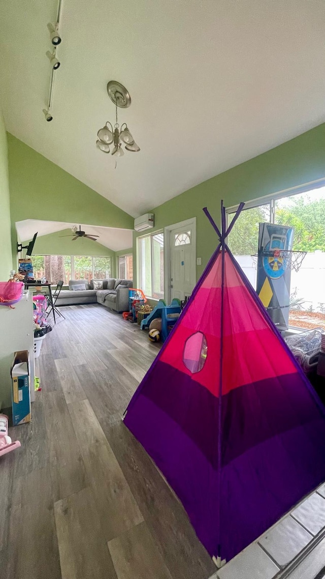 1044 Nin St, Orlando, FL 32835 - playroom with wood finished floors, a wall mounted AC, lofted ceiling, a chandelier, and a ceiling fan