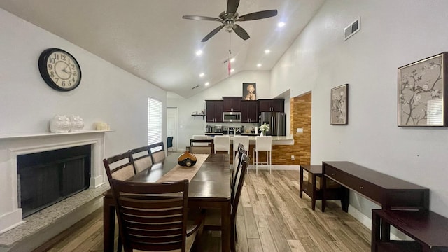 1044 Nin St, Orlando, FL 32835 - dining space featuring light wood-style flooring, a fireplace with raised hearth, ceiling fan, baseboards, and recessed lighting