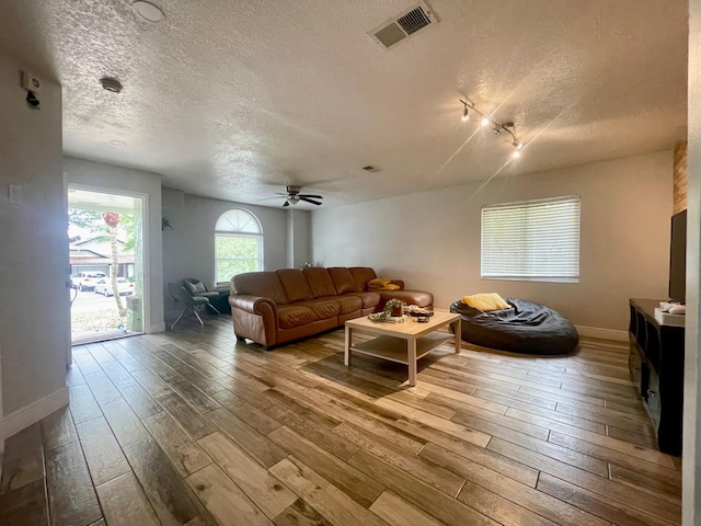 1044 Nin St, Orlando, FL 32835 - living room featuring a textured ceiling, hardwood / wood-style flooring, a ceiling fan, baseboards, and track lighting