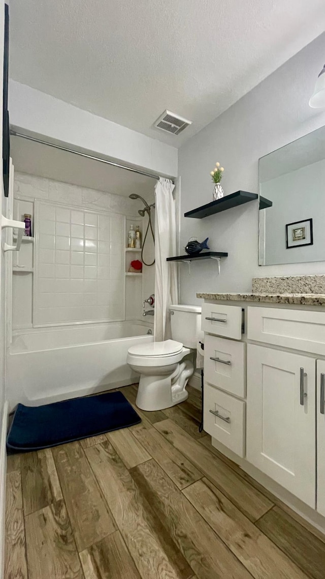 1044 Nin St, Orlando, FL 32835 - full bathroom with wood finished floors, vanity, toilet, shower / bath combo with shower curtain, and a textured ceiling