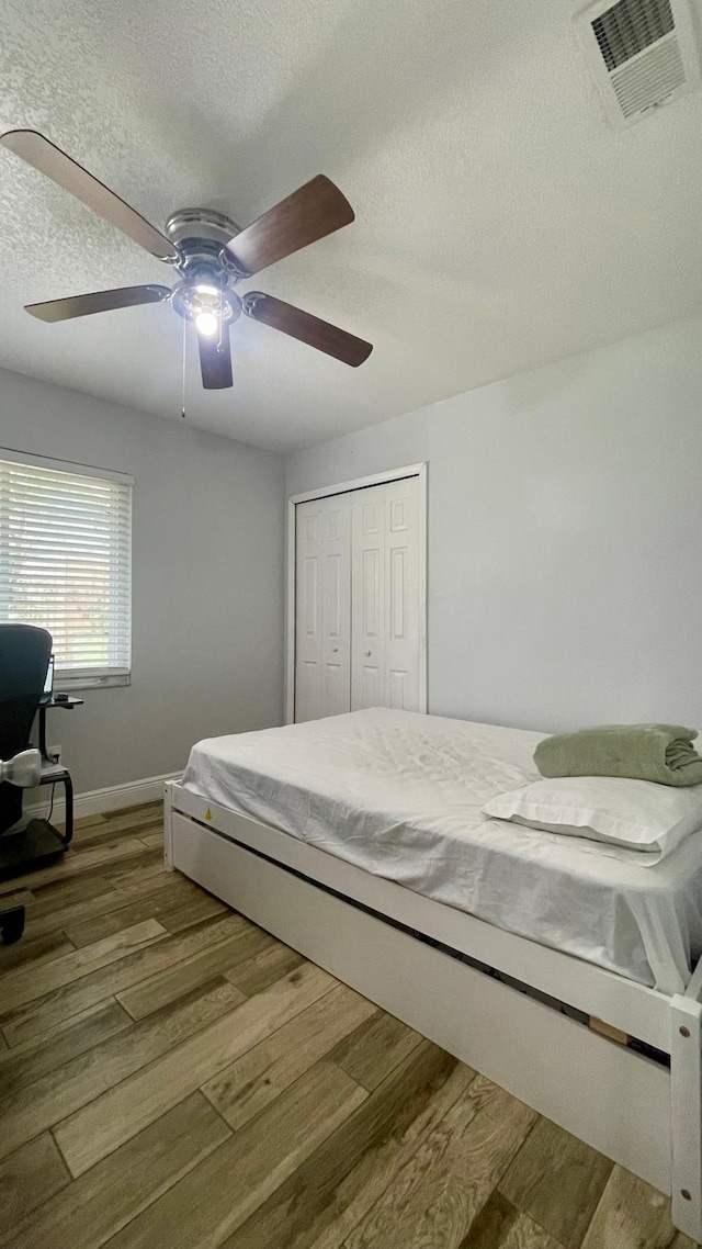 1044 Nin St, Orlando, FL 32835 - bedroom featuring wood finished floors, a textured ceiling, a closet, baseboards, and ceiling fan