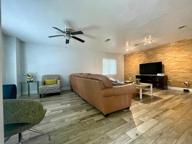 1044 Nin St, Orlando, FL 32835 - living room featuring light wood-style flooring, a textured ceiling, ceiling fan, rail lighting, and baseboards