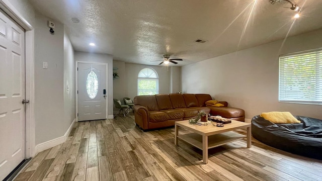 1044 Nin St, Orlando, FL 32835 - living area featuring light wood-style floors, a ceiling fan, a textured ceiling, and baseboards