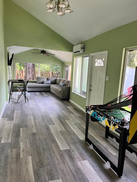 1044 Nin St, Orlando, FL 32835 - living room featuring vaulted ceiling, a chandelier, healthy amount of natural light, and wood finished floors