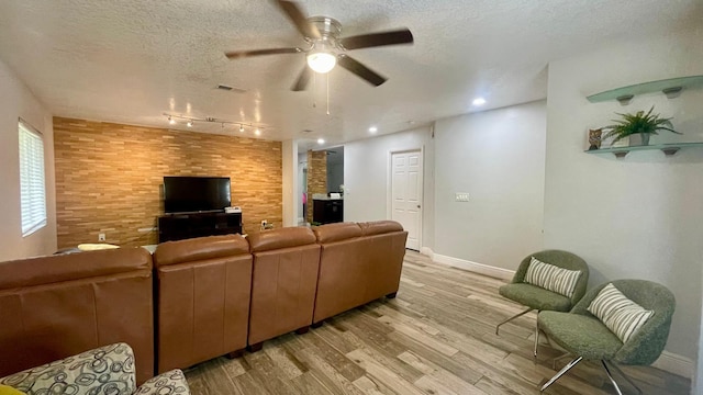 1044 Nin St, Orlando, FL 32835 - living area with track lighting, a ceiling fan, light wood-style floors, a textured ceiling, and baseboards