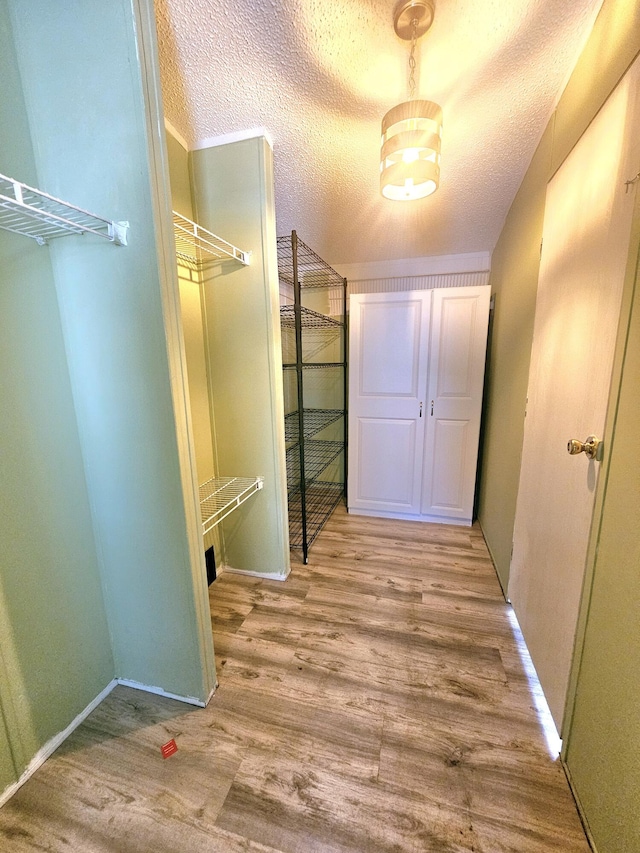 17120 NW 38th Ave, Okeechobee, FL 34972 - hall featuring a textured ceiling, wood finished floors, and baseboards