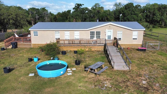 17120 NW 38th Ave, Okeechobee, FL 34972 - back of property with metal roof, a lawn, a deck, and fence