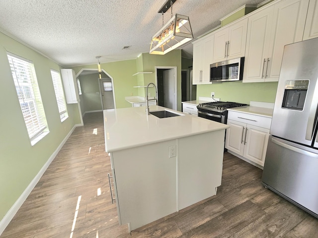 17120 NW 38th Ave, Okeechobee, FL 34972 - kitchen with a sink, stainless steel appliances, light countertops, a textured ceiling, and an island with sink